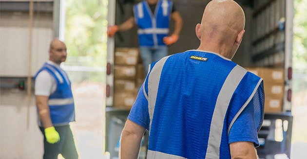 Warehouse Workers Wearing Enhanced Visibility Safety Vests